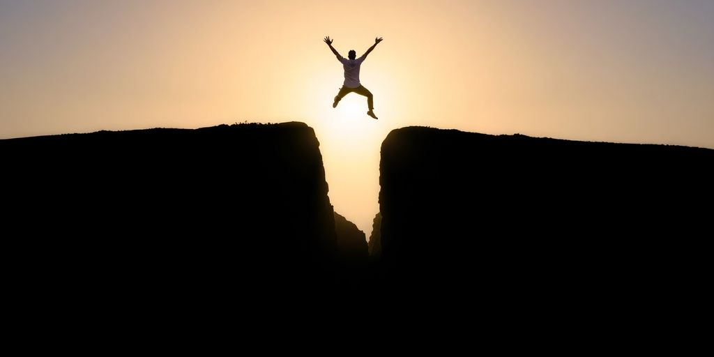 Person climbing towards a bright, open sky.